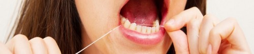 woman flossing her teeth to maintain great oral health